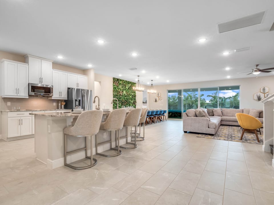 - Open concept living area with kitchen, dining and lounge combined  
- Long island bar with stools perfect for vacation group meals  
- Spacious seating area designed for family gatherings and comfort