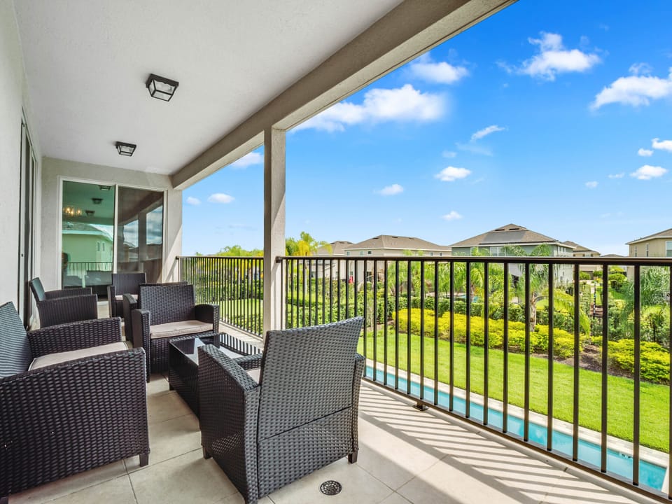 - Balcony lounge with wicker seating and garden view  
- Peaceful outdoor retreat overlooking the pool  
- Relaxing spot for coffee or evening gatherings