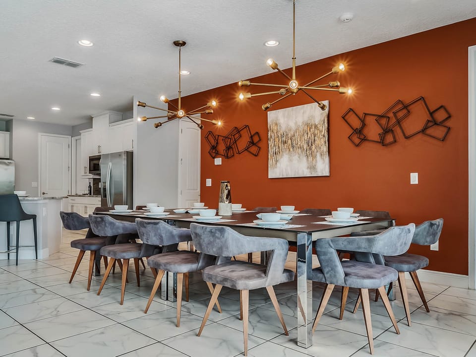 - Dining area with bold orange accent wall decor  
- Stylish chandelier lighting for cozy dinners  
- Large table with seating for family gatherings