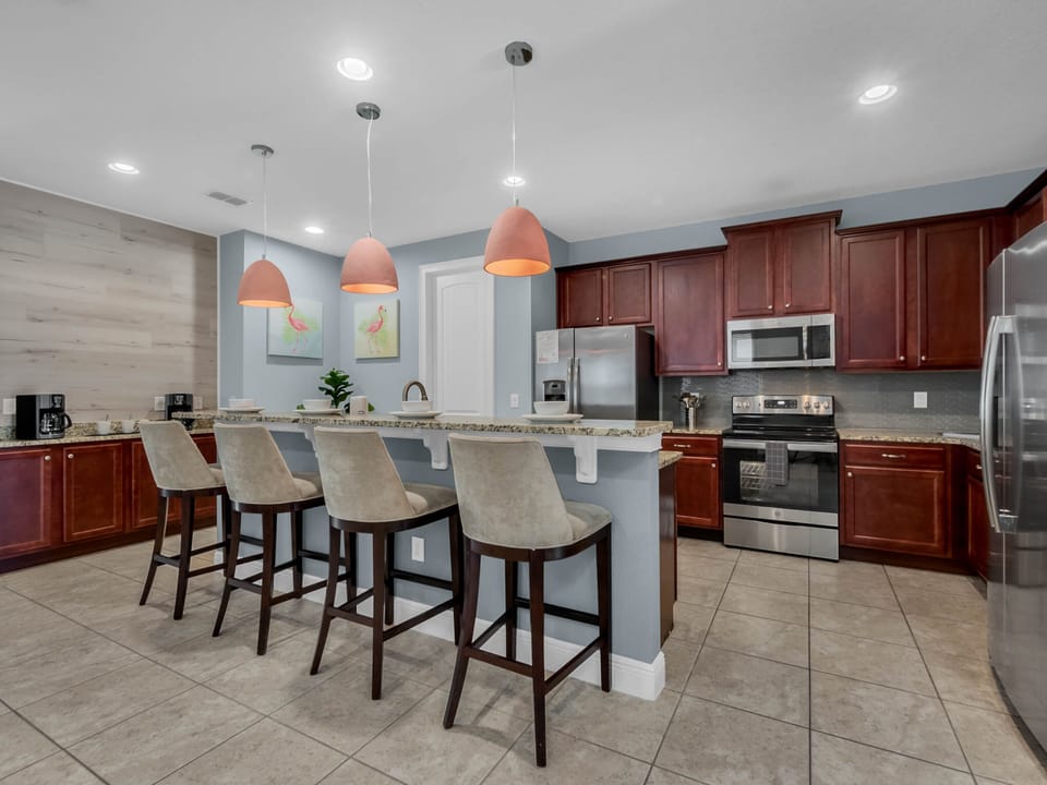 - Spacious kitchen with granite counters and modern appliances for group dining  
- Bar seating and pendant lights create an inviting vacation setup  
- Ideal for preparing meals during family stays near attractions