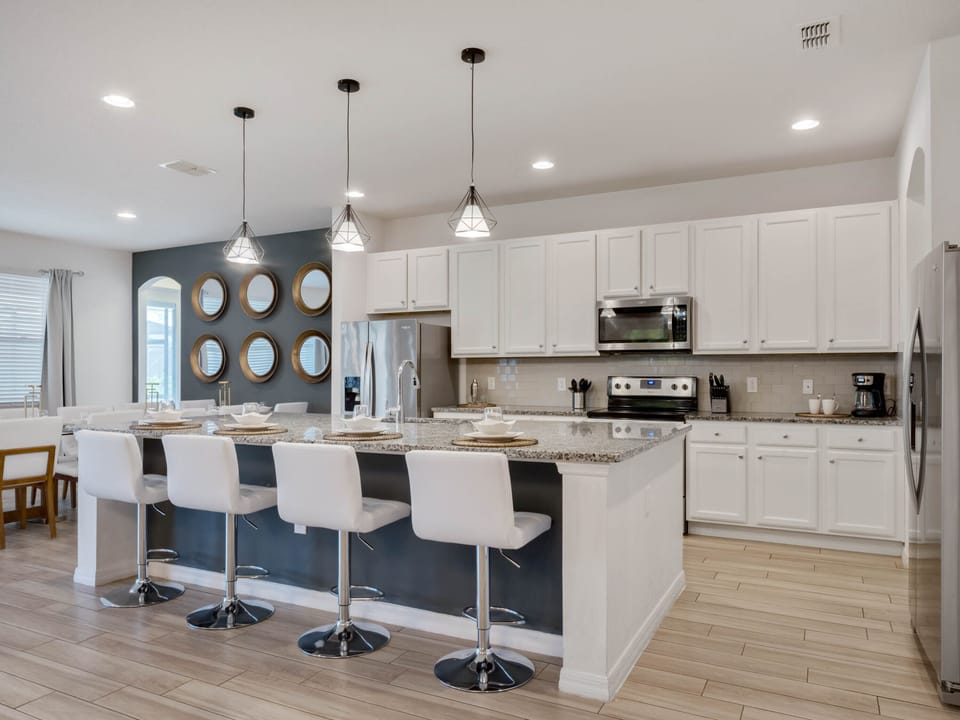 - Modern kitchen with granite counters and stainless appliances  
- Large island with seating for four connects to open floor plan  
- Perfect space for cooking and gathering with family and friends