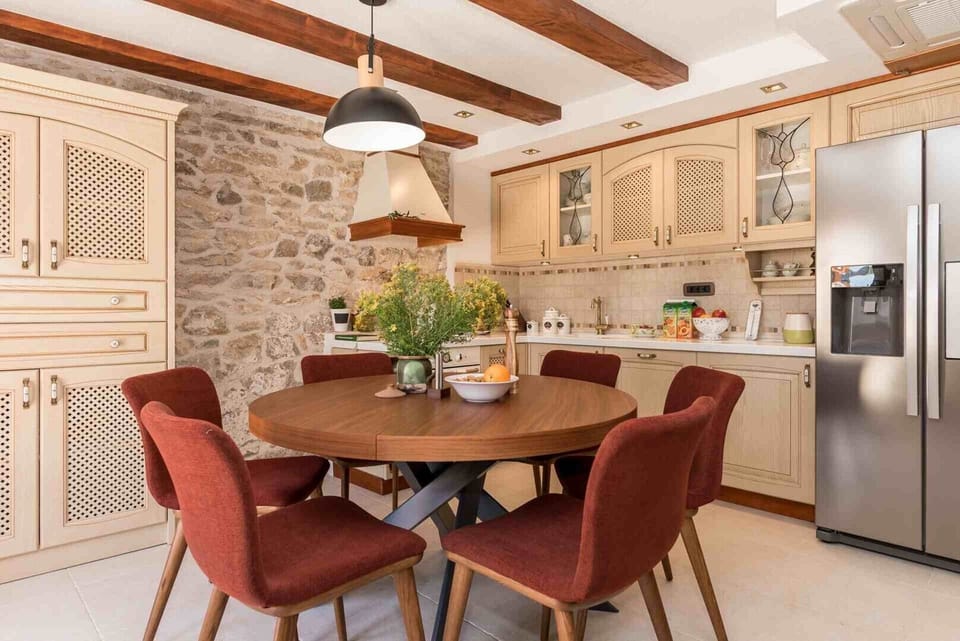 Dining table and kitchen on the ground floor of a luxury family villa with heated pool and wifi
