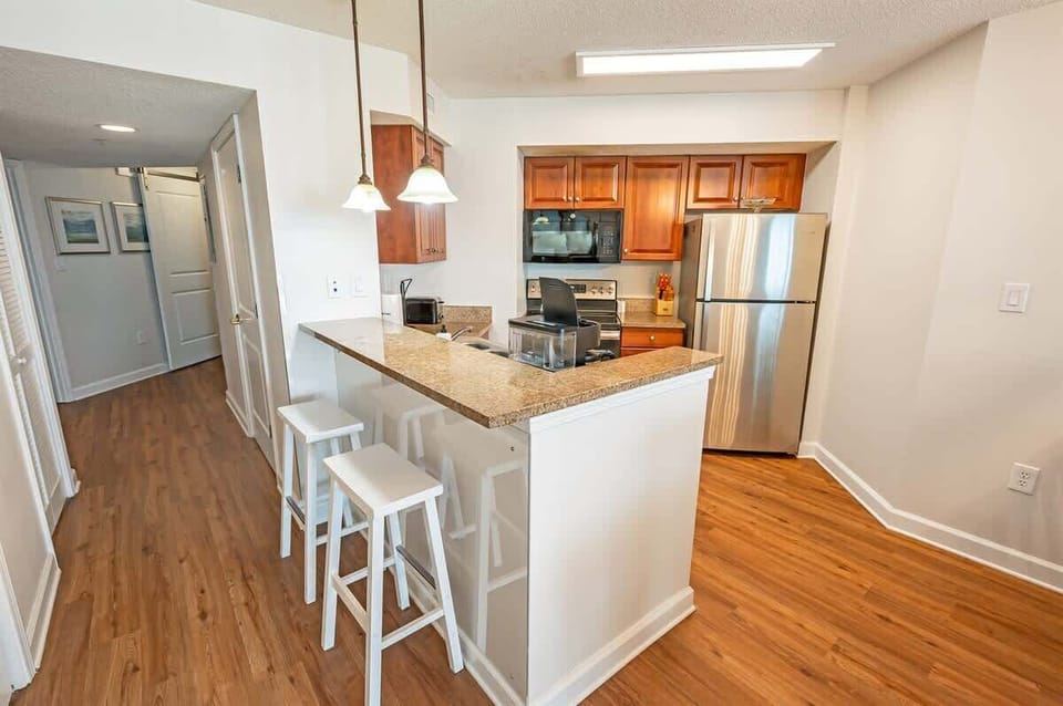 - Kitchen with stainless steel fridge and granite bar   - Fully equipped with oven, stove, and microwave setup   - Open design ideal for preparing meals during stays