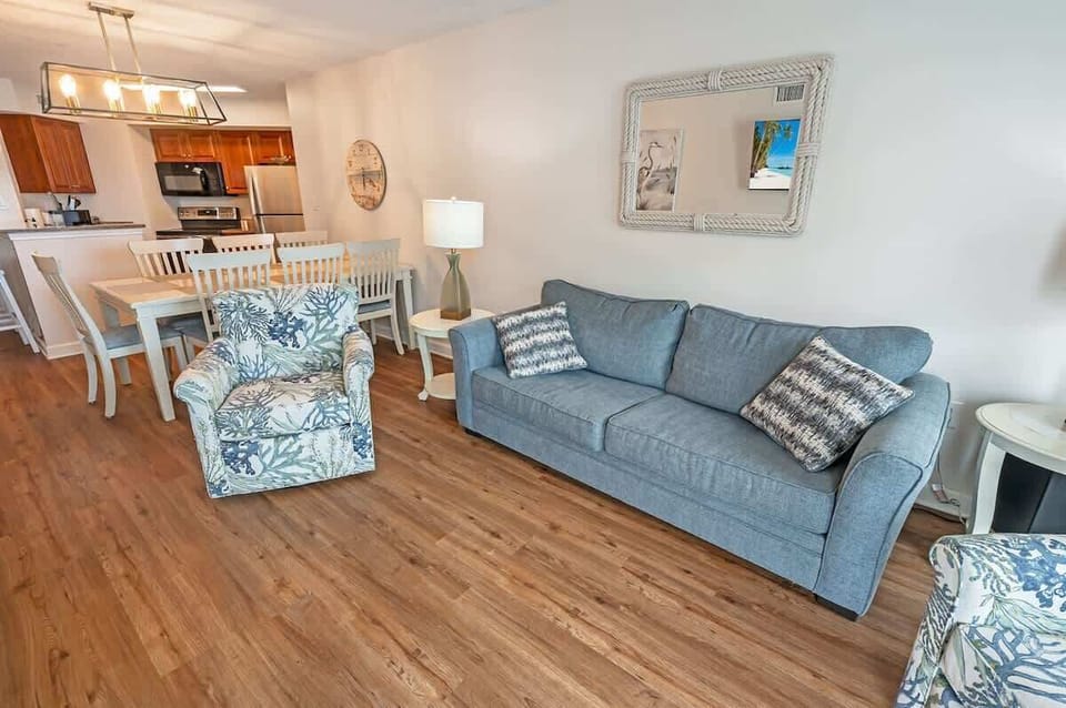- Cozy sofa seating with direct ocean view balcony   - Open floor plan connects living and dining areas   - Relax with beach-inspired décor and modern setup
