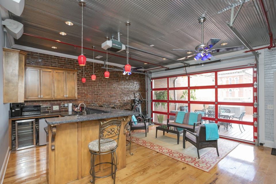 - Nashville loft bar with brick walls and bright pendant lights   - Granite counter and open layout connect to the outdoor deck   - Great entertainment setup for gatherings and game days