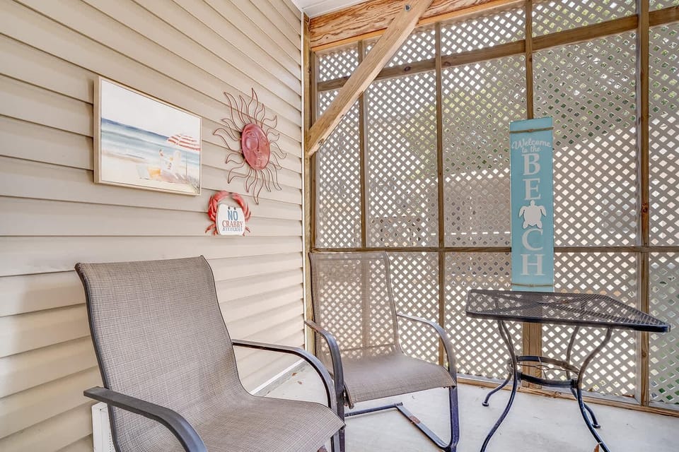 Cozy screened porch with relaxing seating and ocean decor