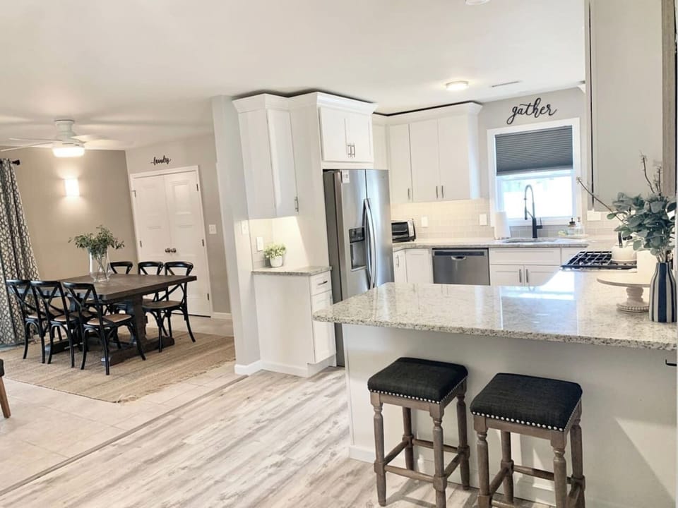 Our modern kitchen flows seamlessly into the dining area, featuring granite counters, stainless appliances, and a breakfast bar. The farmhouse dining table seats six, making it the perfect hub for family meals and conversation.