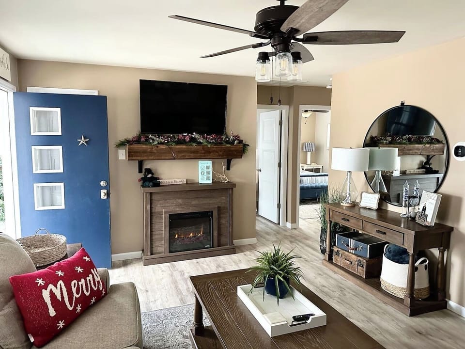 Nothing beats the early glow of the holidays! In November, the living area is transformed into a warm, seasonal retreat featuring a cozy fireplace, holiday greenery on the mantle, and festive accents that make the space feel like home for the holiday.