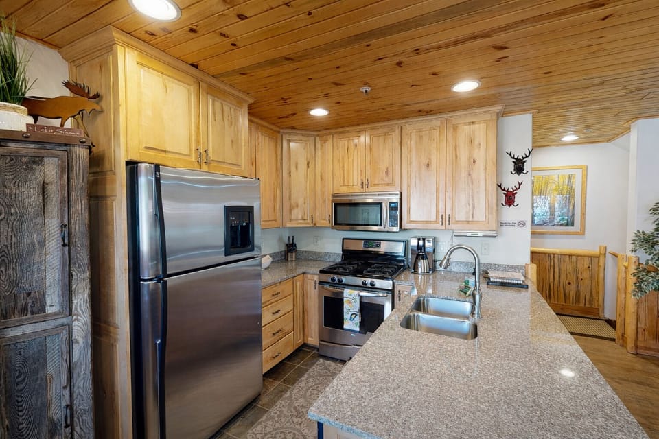 Your fully-equipped kitchen features warm wood cabinets, granite counters, and stainless appliances..