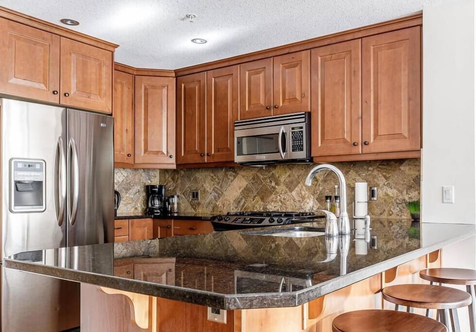 Beautifully equipped kitchen with granite countertops and stainless steel appliances, and well stocked with fresh local coffee beans, tea, and condiments
