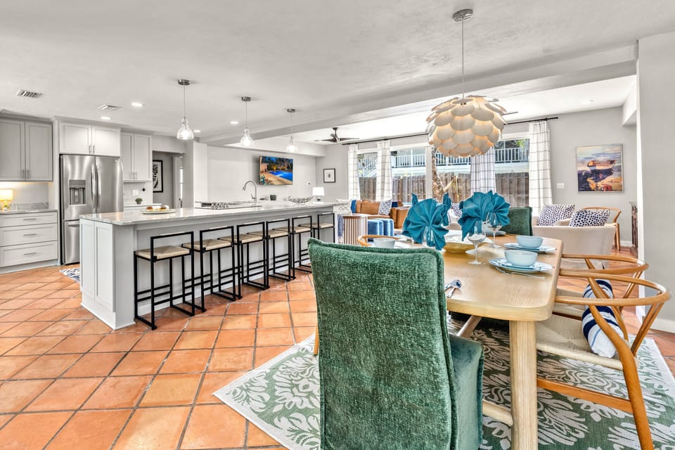 This wide view captures the full flow of the space—kitchen, dining, and living room all connected in one bright, open layout.