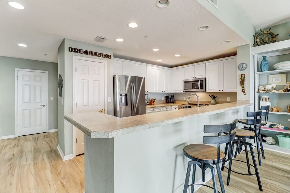 Fully Equipped Kitchen with Stainless Steel Appliances and Bar Stool Seating for 4
