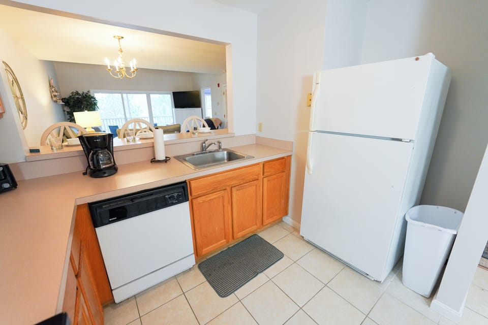9405 Pettinaro Drive - Kitchen Sink and Refrigerator - Alternate angle of the kitchen area, showing the double-basin sink, white refrigerator, and dishwasher.