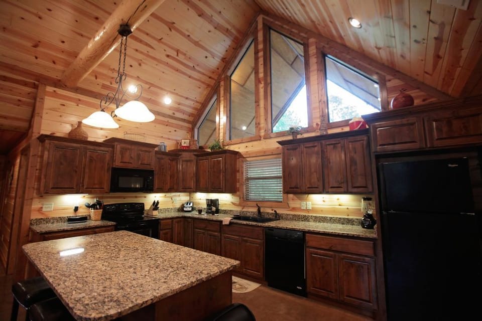 Rustic cabin kitchen with soaring windows, expansive counter space, and warm wood charm