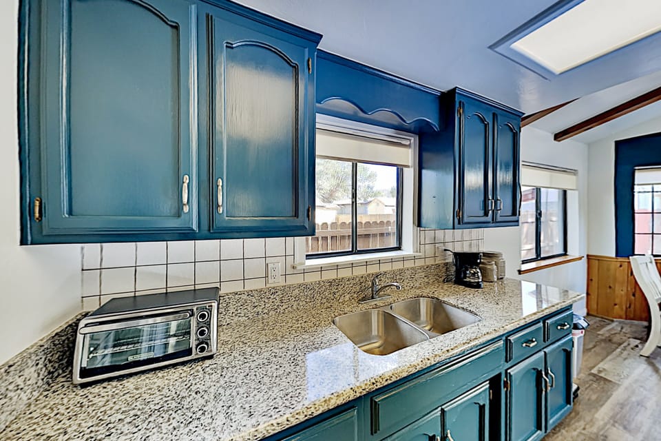 Kitchen with new granite counter tops and freshly painted cabinets.