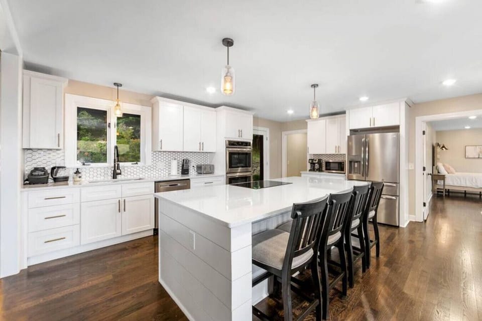 Kitchen island with four barstools and designer pendant lighting