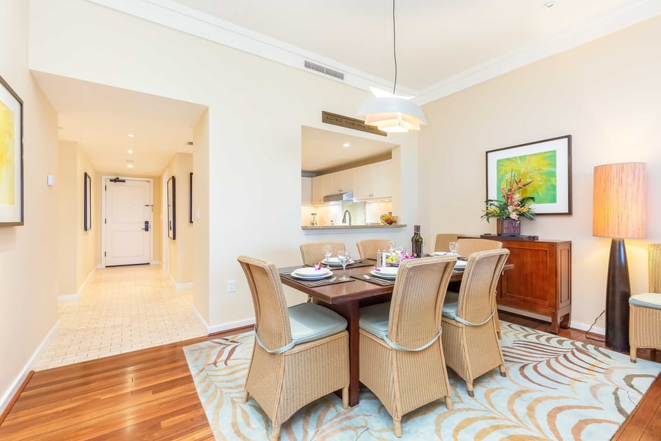 Dining table for six with woven chairs and tropical decor, ideal for shared meals.