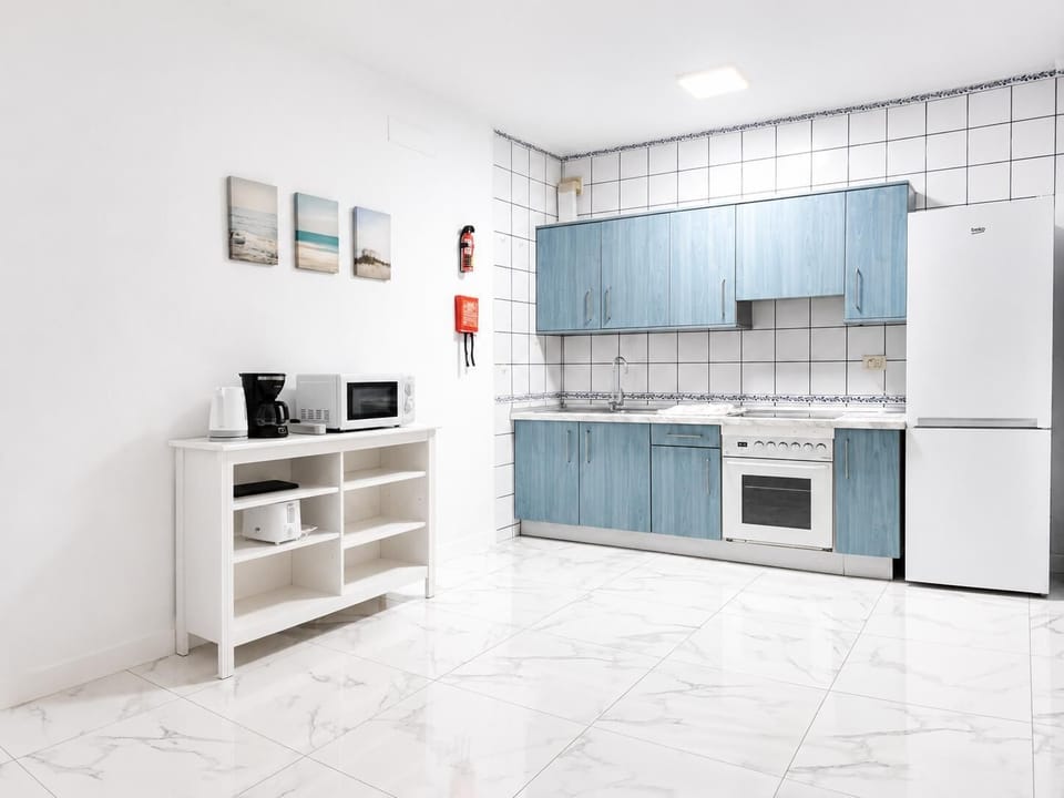 Open-plan living room with sofa, dining area, kitchen, A/C, WiFi internet, and satellite TV