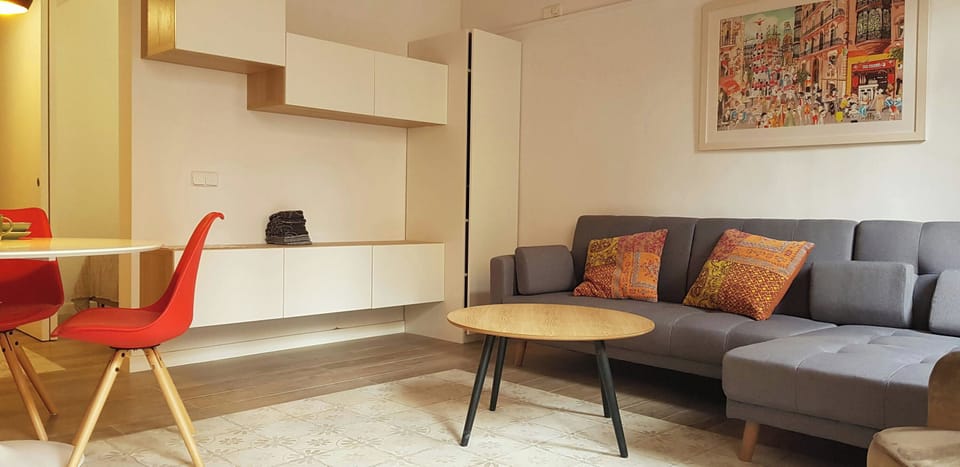 The living room is a bright and airy space with a large, comfortable grey sofa. In case of separate sleeping arrangements, the sofa can be converted into a sofa bed (upon prior request).