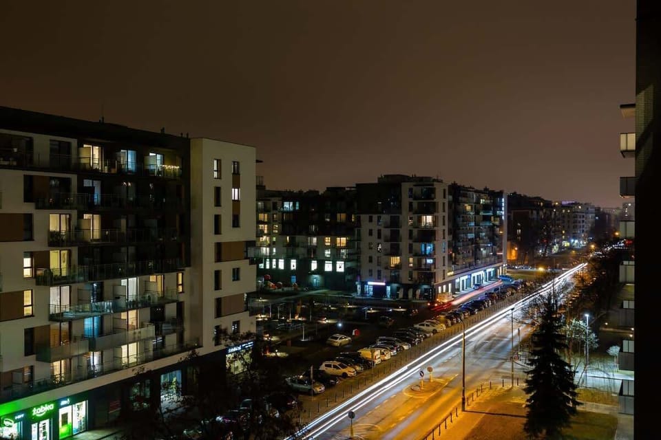 A view of a bustling city at night, with well-lit streets and modern buildings.