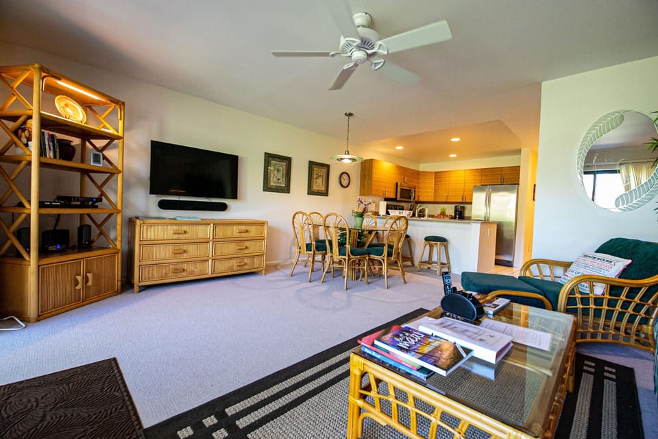 Relax in your tropical-inspired living area with comfortable rattan seating, entertainment center, and open flow to the dining space and fully-equipped kitchen.