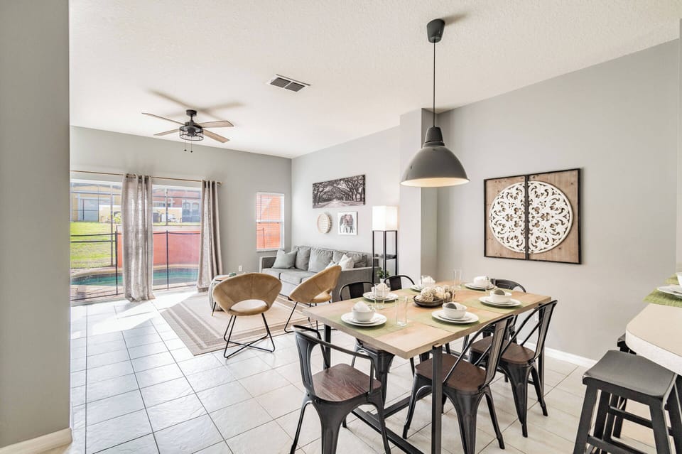 Join us at the rustic wooden dining table, where a carefully set meal awaits. A warm pendant light enhances the inviting ambiance, blending indoor comfort with beautiful outdoor views for a perfect relaxing experience.