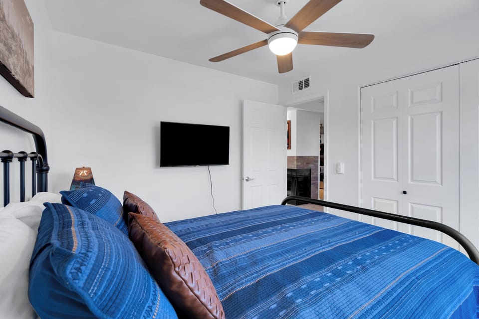 Guest bedroom with queen bed, 40" Roku TV, and ceiling fan