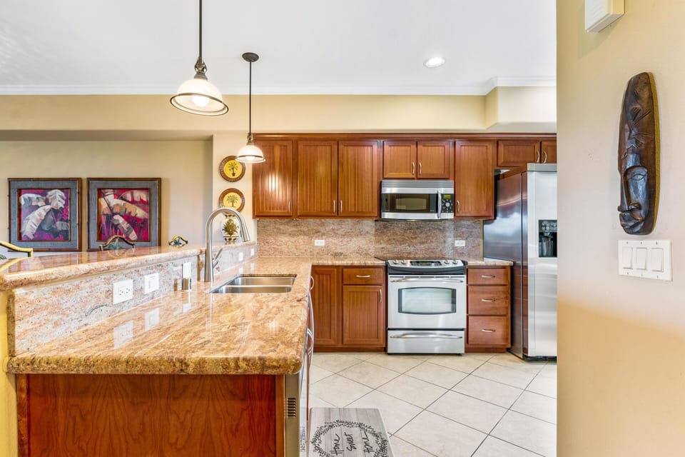 Full kitchen with breakfast bar, granite counters, and stainless steel appliances