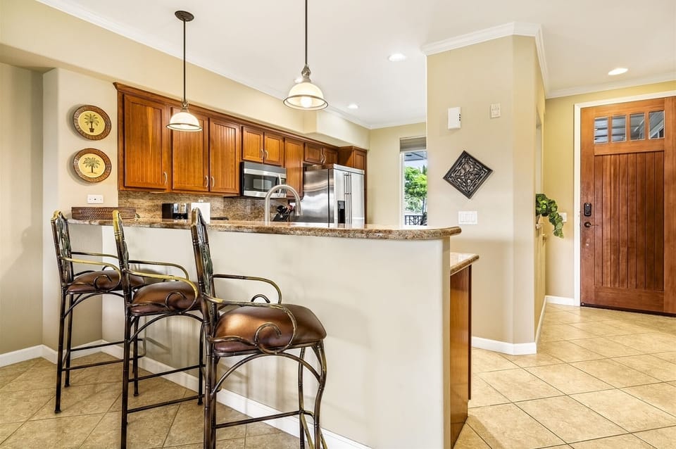 Full kitchen with breakfast bar, granite counters, and stainless steel appliances