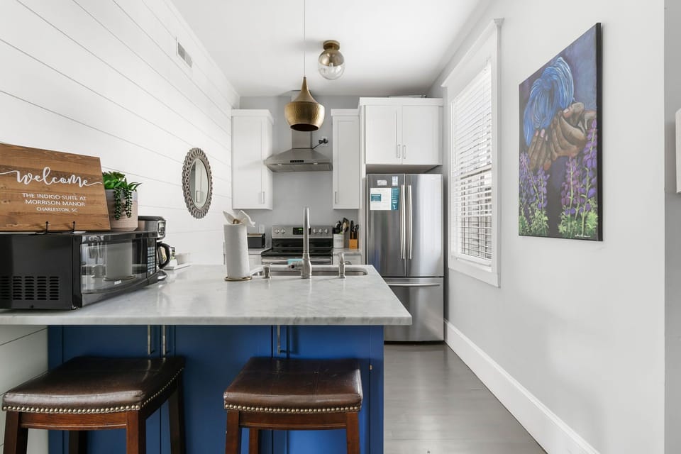 Sleek white cabinets paired with deep blue accents for a bold, elegant look.