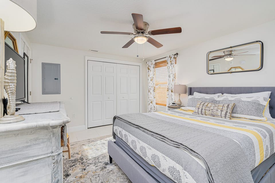 Rest easy in your stylish bedroom with plush bedding, ceiling fan, and charming vintage touches that make every night feel luxurious.
