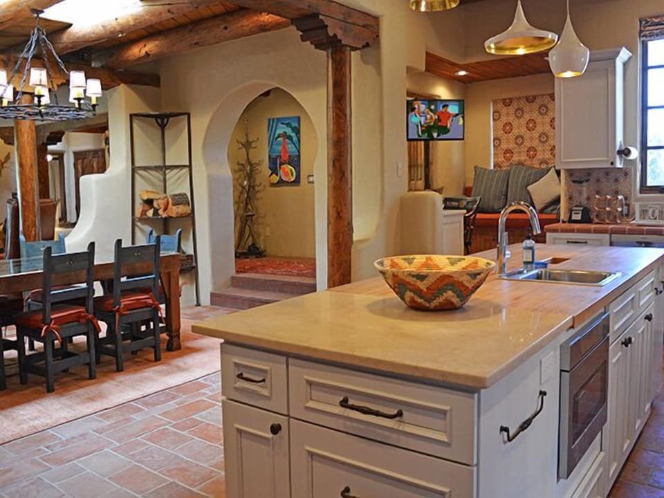 In the open plan designer kitchen, a television swings easily between the kitchen and a cozy window seat alcove with computer desk.