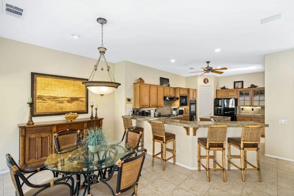 Spacious dining area with glass table and counter stools