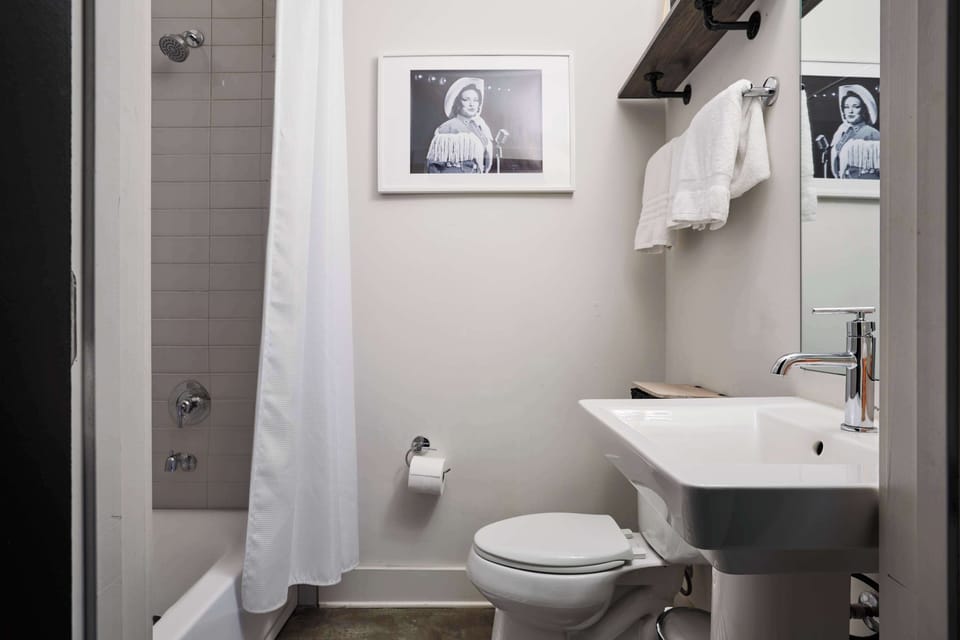 Featuring vintage portraits and sleek finishes, this bathroom is a tribute to Nashville’s musical roots.