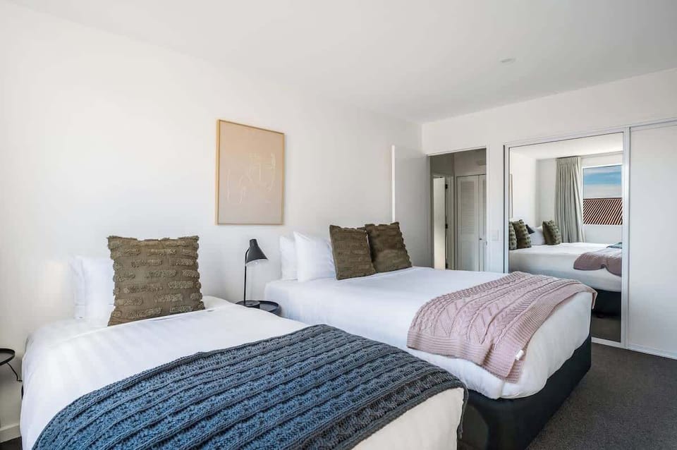Cozy bedroom with queen and single beds, offering ample storage—perfect for your Queenstown stay, with room for all your gear and essentials.
