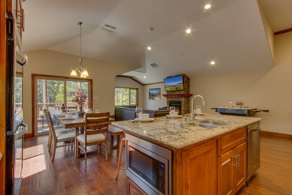 - Open concept dining and living area design  
- Kitchen island seating and family dining table  
- Fireplace and balcony views with natural light