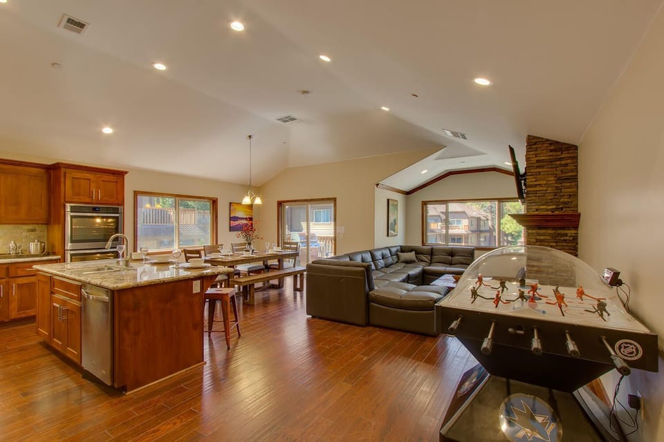- Open-concept living with game and dining space  
- Air hockey table for family fun and entertainment  
- Large sectional sofa with TV and fireplace
