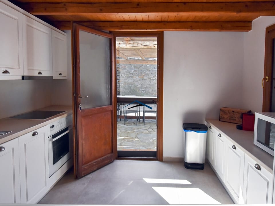Fully equipped kitchen with direct access to one of the dining areas and the BBQ