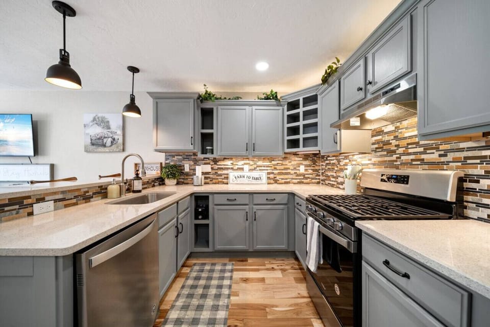 The open-concept kitchen has a gas stove, microwave, dishwasher, and fridge. It is fully stocked with all basic utensils. The  breakfast bar has three seats looking in to the kitchen.