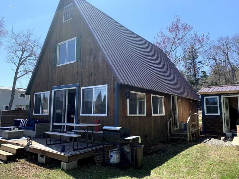 it is an A frame home with the deck facing the lake