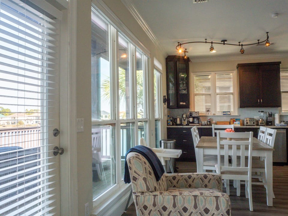 Dining area and kitchen next to wall of windows with water view