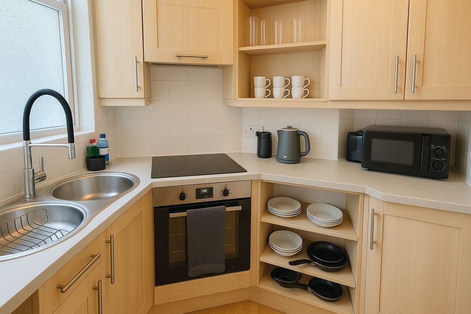 Bright, functional kitchen with a sleek, minimalist design. Light wood cabinetry, a built-in oven, electric cooktop, fridge with freezer compartment, washing machine and organized open shelving create a warm, practical space for cooking and dining.