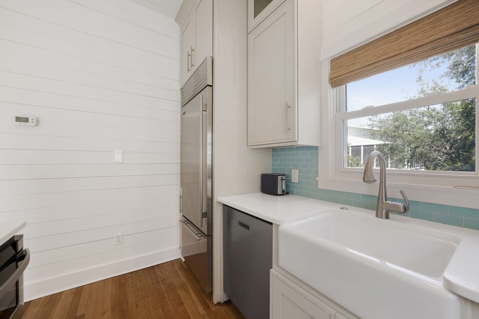 VIEW TO LARGE SUB ZERO FRIDGE, DISHWASHER, FARMHOUSE SINK
