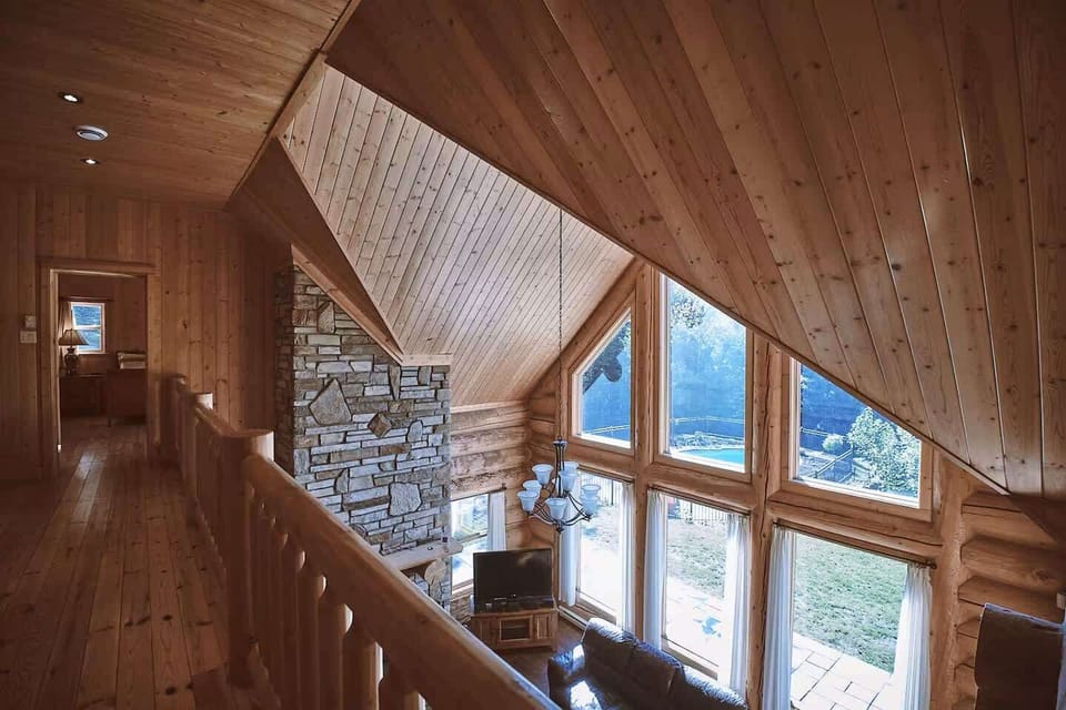 Upper hallway overlooks the living room’s dramatic floor-to-ceiling windows