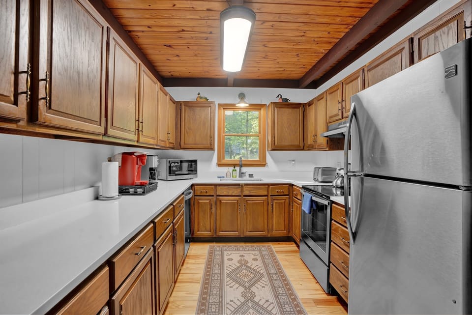 Fully stocked kitchen with steel appliances and lakefront view.