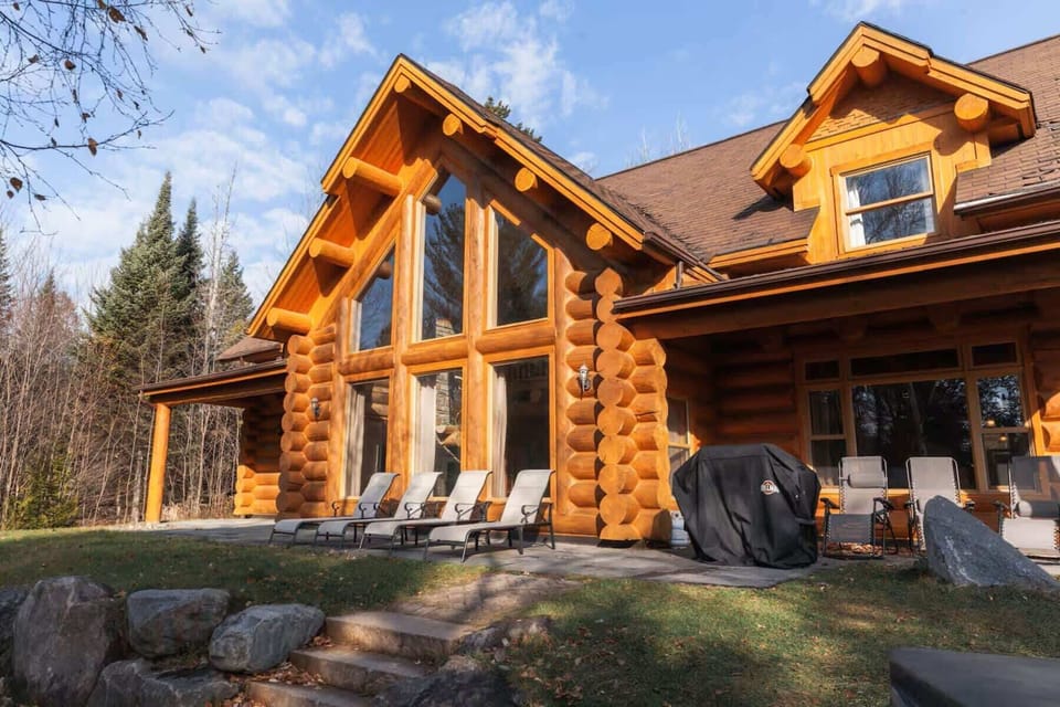 Sunlit patio with lounge chairs along the cabin’s facade