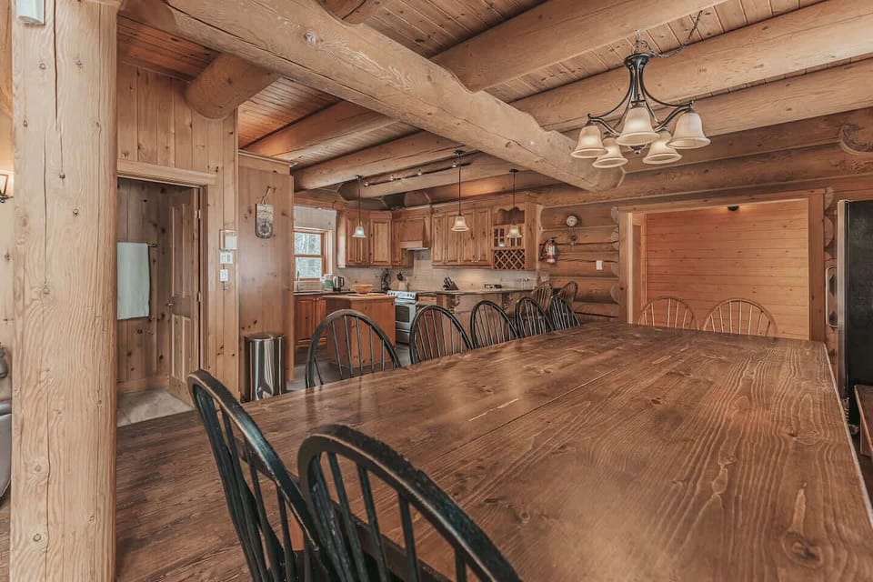Long rustic dining table with black chairs perfect for group meals