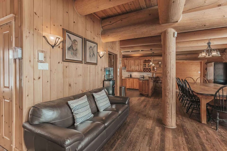 Open dining and living area with natural wood beams and spacious design