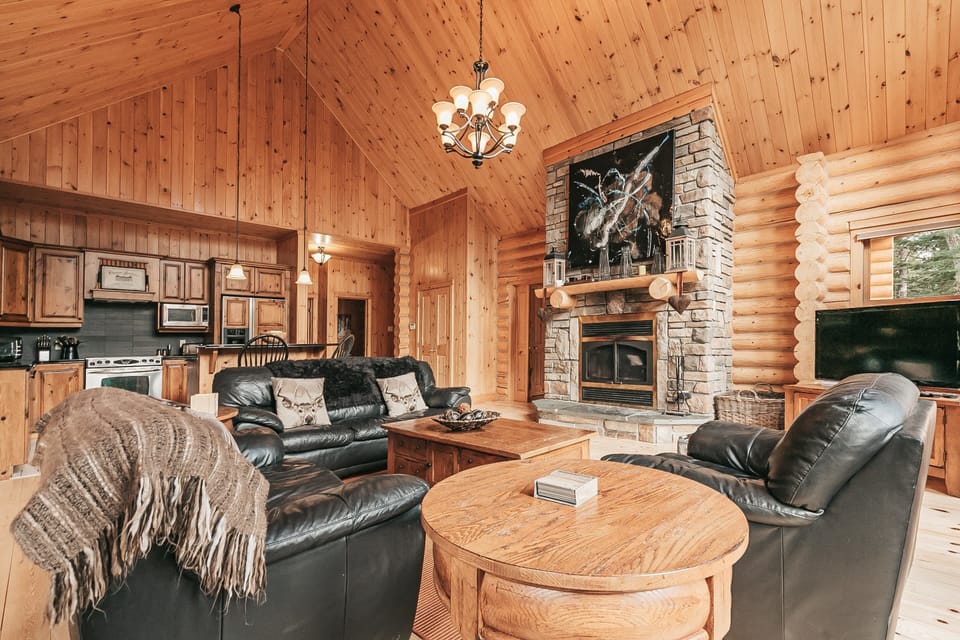 Comfortable living area with leather chairs and stone fireplace
