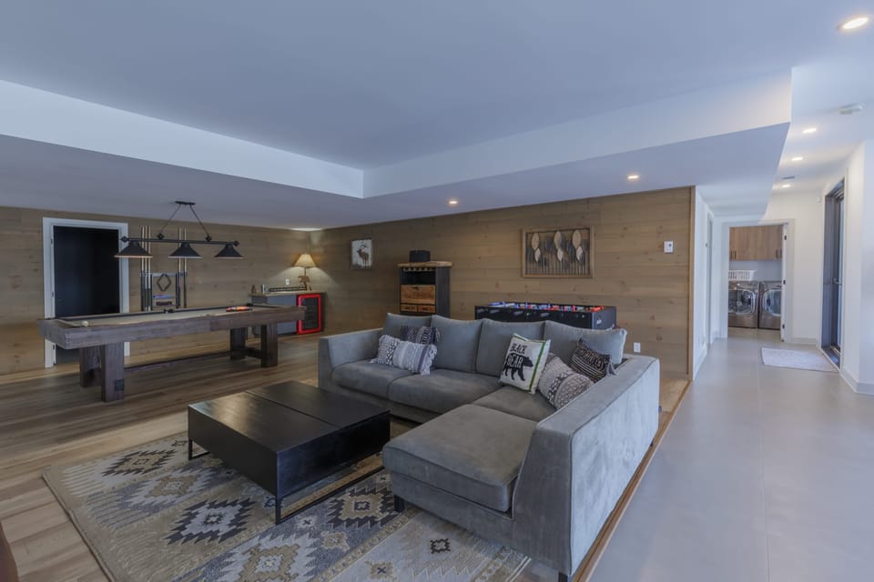 Spacious game room with sectional, pool table, and foosball for group fun
